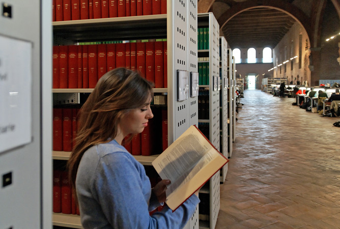 Studentessa consulta un libro in Sala Crociera